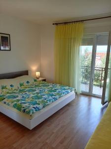 - une chambre avec un lit et une grande fenêtre dans l'établissement Apartments with a parking space Novi Vinodolski - 2416, à Novi Vinodolski