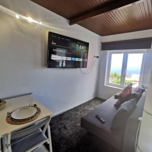 ein Wohnzimmer mit einem Sofa und einem TV an der Wand in der Unterkunft La Montaña 2 in Sabinosa