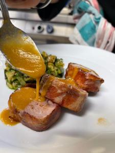 a plate of food with meat and sauce on a spoon at Agriturismo Filippon in Tambre dʼAlpago