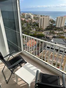 een balkon met een stoel en een tafel en de oceaan bij Atlantic Sunset Floor - Las Americas in Playa de las Americas