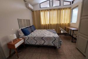 1 dormitorio con cama, escritorio y ventana en 1Brm Apartment few steps to Malls, en Antiguo Cuscatlán