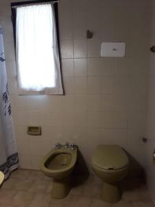 baño con aseo verde y ventana en Departamentos El Nogal en Mina Clavero