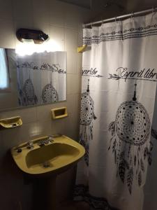 baño con lavabo y cortina de ducha en Departamentos El Nogal en Mina Clavero
