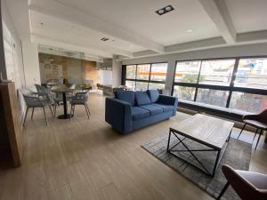 sala de estar con sofá azul, mesas y sillas en Hermosa Vista en Chapinero cómodo wifi, en Bogotá
