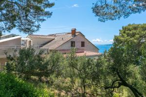 ein Haus auf einem Hügel mit dem Ozean im Hintergrund in der Unterkunft Apartments by the sea Brela, Makarska - 18356 in Brela