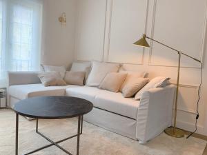 ein Wohnzimmer mit einem weißen Sofa und einem Tisch in der Unterkunft Lujoso apartamento boutique a estrenar con parking gratis in Gijón