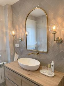 ein Badezimmer mit einem Waschbecken und einem großen Spiegel in der Unterkunft Lujoso apartamento boutique a estrenar con parking gratis in Gijón