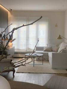 ein Wohnzimmer mit einer weißen Couch und einem Ast in der Unterkunft Lujoso apartamento boutique a estrenar con parking gratis in Gijón