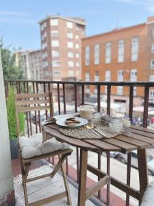 einen Holztisch und Stühle auf dem Balkon in der Unterkunft Lujoso apartamento boutique a estrenar con parking gratis in Gijón