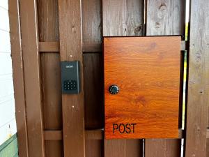 drewniane drzwi z znakiem pocztowym w obiekcie 奄美大島の一棟貸切のヴィラAmalog アマログ w mieście Akaoki