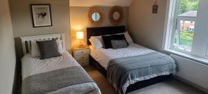 a bedroom with two beds and a window at Homebird Property - Rutland Apartment in Harrogate