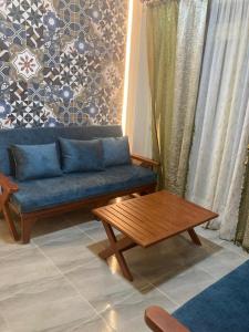 a living room with a blue couch and a coffee table at Pharma beach resort قريه الصيادلة - Chalet - zero ten six four one seven six five zero nine in Balṭîm