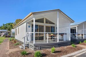 a mobile home with a porch and a deck at Reflections Ferry Reserve - Holiday Park in Brunswick Heads