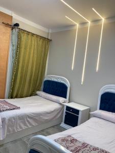 a room with two beds and a window at Pharma beach resort قريه الصيادلة - Chalet - zero ten six four one seven six five zero nine in Balṭîm