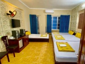 Pokój z 2 łóżkami, biurkiem i telewizorem w obiekcie Khánh Vân - VT Cloud mini Hotel w mieście Vung Tau
