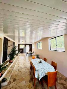 a dining room with a table and chairs and a living room at CHEZ ANIAKI in Nuku Hiva