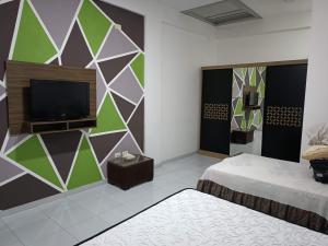 a room with two beds and a flat screen tv at DeDyAn 13 in Santa Cruz de la Sierra