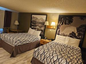 um quarto de hotel com duas camas ao lado uma da outra em Wyo Inn em Sheridan