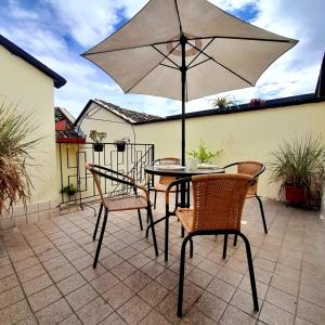 een tafel en stoelen met een parasol op een patio bij Hostal Antonio in Popayan