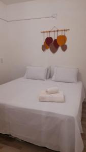 a white bed with towels on top of it at Quarto Dani in Jericoacoara