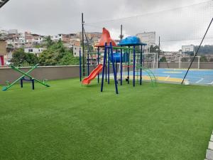 um parque infantil com um escorrega num campo de relva em Confortable apartamento em Manizales