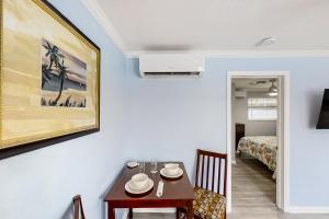 a dining room with a table and a bed at Dolphin Court #3 in St. Pete Beach