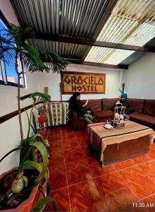 un hombre sentado en un sofá en una sala de estar en Hostal Graciela en Oruro