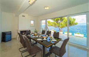 a dining room with a table and chairs and the ocean at Awesome Home In Crnja Luka With Kitchen in Prigradica