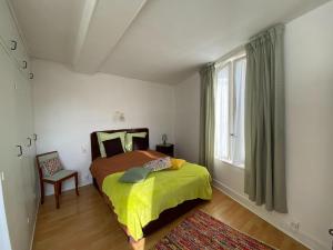 a bedroom with a bed and a chair and a window at Apartment in Fécamp near Cap Fagnet Cliffs in Fécamp