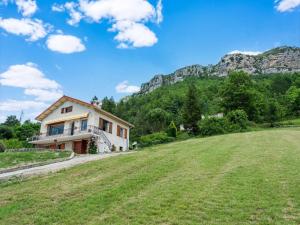 uma casa numa colina com um campo verde em Spacious holiday home in Saint-Julien-du-Verdon with garden em Saint-Julien-du-Verdon