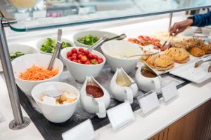 un buffet con muchos tazones de comida en un mostrador en ホテル　ロモサ en Minakami