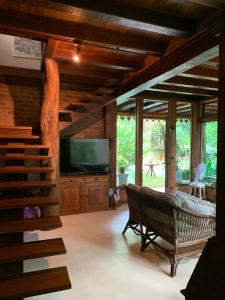 a living room with a couch and a tv and stairs at Guest House Tânia Alves in Pratinha