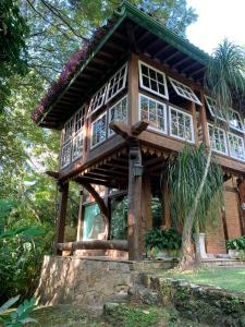 a wooden house with a cross in front of it at Guest House Tânia Alves in Pratinha
