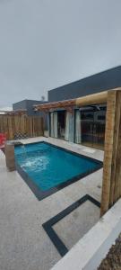 a swimming pool in front of a house at Villa Maré Guaratiba Beach in Prado