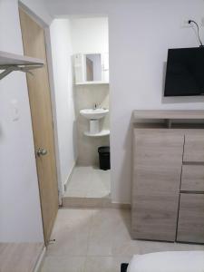 a bathroom with a sink and a toilet and a door at Edif HA in Cartagena de Indias