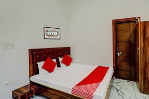 a bedroom with a large bed with red pillows at Flagship Rudra Banquet And Resorts in Morādābād