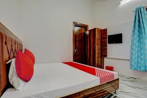 a bedroom with a bed with red pillows at Flagship Rudra Banquet And Resorts in Morādābād