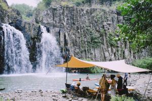 a group of people standing in front of a waterfall at Laé Hostel in Tuy Hoa