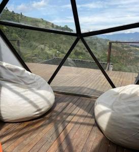 コパカバーナにあるGlamping ecoglam Medellínの白い枕が備わるガゼボの内側からの景色