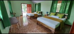 een slaapkamer met 2 bedden en een stoel in een kamer bij Cabinas Tortuguero Sports Fishing in Tortuguero