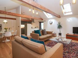 uma sala de estar com um sofá e uma mesa em The Cart Lodge at Grove Barn em Eye