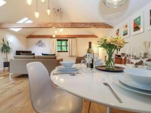 a dining room and living room with a white table and chairs at The Cart Lodge at Grove Barn in Eye