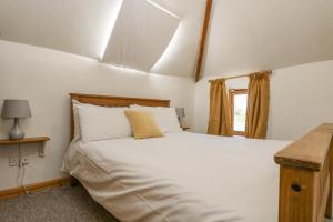 a bedroom with a large white bed and a window at The Wagon Linney in Bude