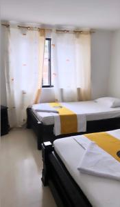 2 Betten in einem Zimmer mit Fenster in der Unterkunft Hotel sol de uraba in Apartadó