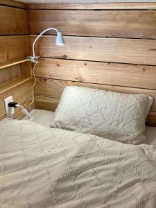 1 dormitorio con 1 cama con cabecero de madera en Surfer's Cafe& Hostel, en Chatan
