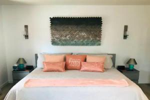 a bedroom with a bed with pink pillows on it at Artsy Casita, King Bed, Walk to Trails & Food, Mountain Views, Trail Pass in Sedona