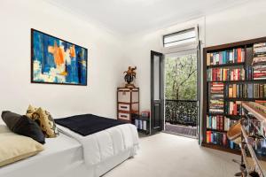 um quarto com uma cama e uma estante de livros com livros em Paddington house beautiful 2 bedroom terrace em Sydney