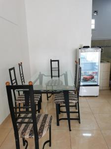 d'une table à manger avec des chaises et un réfrigérateur. dans l'établissement Wubao Villa dekat hotel Le Eminence Kota Bunga, à Cikundul