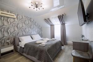 a bedroom with a bed with two towels on it at Готель Гайсин «Тіроль» in Haysyn