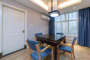 een eetkamer met een zwarte tafel en blauwe stoelen bij Morninginn, Zhenyu Plaza in Shaoyang County +18 foto's